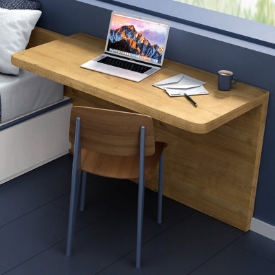 Escrivaninha em madeira clara com cadeira de madeira e metal, portátil, caderno, caneta e caneca num espaço interior