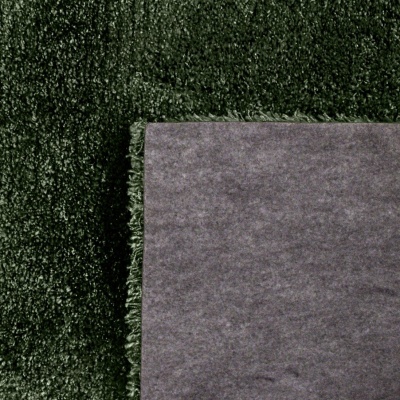 Pedaço de tapete cinzento sobre superfície verde escura felpuda
