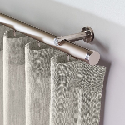 Varão de cortina metálico prateado com cortina cinza claro transparente em tecido de malha.