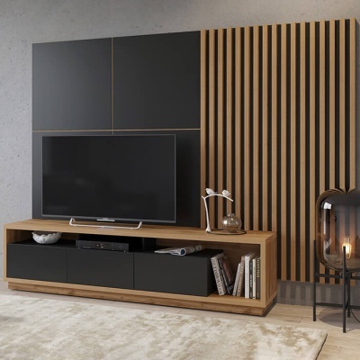 Móvel TV em madeira clara com portas pretas, televisão, livros, candeeiro de vidro e painel de madeira vertical ao fundo