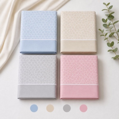 Conjunto de quatro lençóis coloridos com padrão hexagonal dobrados sobre fundo branco.