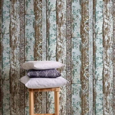 Almofadas empilhadas num banco de madeira contra parede com papel de parede de padrão rústico