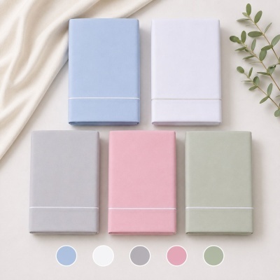 Cinco capas de edredão em cores pastel, dobradas em fundo claro com folhas verdes.