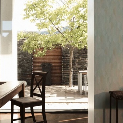 sala de jantar com mesa de madeira e cadeiras, porta aberta para jardim ao fundo