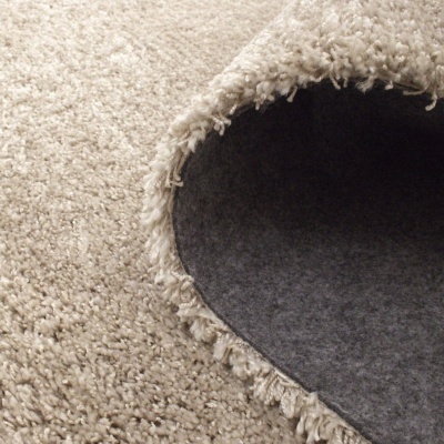 Tapete bege felpudo com bordas desfiadas, parte inferior cinzenta escura