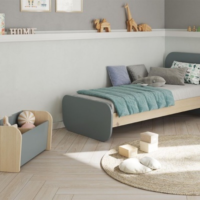 Quarto infantil com cama de solteiro em madeira e cinza, colcha verde água, almofadas e caixa de brinquedos