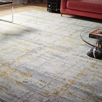 Tapete cinza com padrão abstrato em tons de amarelo e bege numa sala junto a sofá vermelho e mesa de vidro