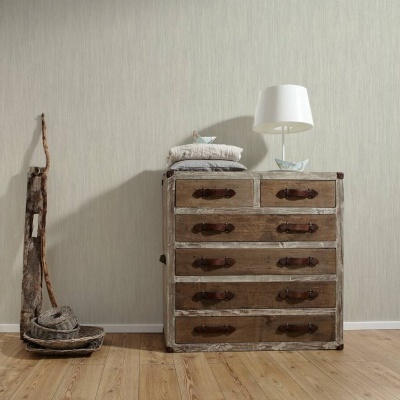 Cômoda rústica de madeira com gavetas e luminária branca numa sala com chão de madeira