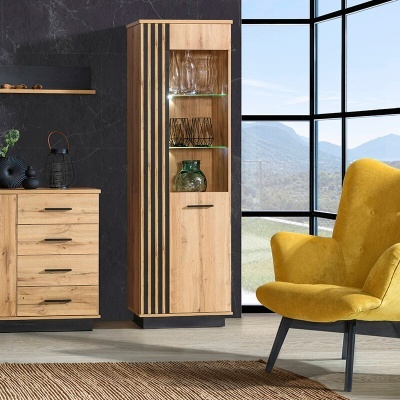 Móvel de madeira clara com porta e prateleiras em vidro, em sala com poltrona amarela e janela grande