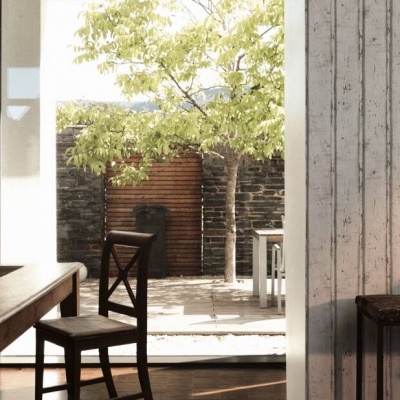 Sala de jantar com mesa e cadeiras de madeira e vista para pátio exterior