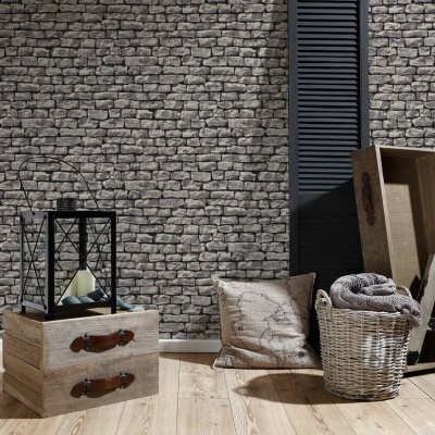 Conjunto decorativo com caixas de madeira, lanterna e almofada contra parede de pedra