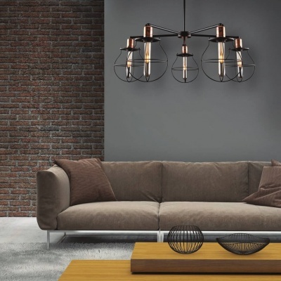 Sofá castanho em sala com parede cinzenta e de tijolos, candeeiro metálico e mesa de madeira com decoração