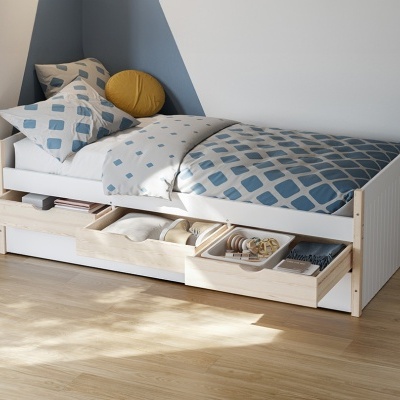 Cama individual branca com gavetas de arrumação e roupa de cama azul e branca