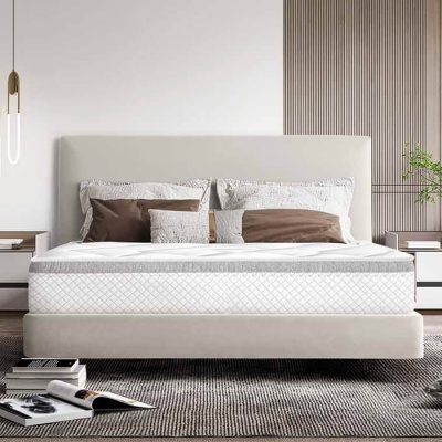 Cama dupla estofada bege com colchão branco e almofadas castanhas e brancas num quarto moderno