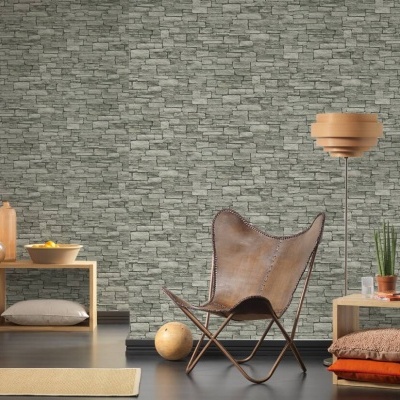 Sala de estar com cadeira de couro castanho e parede de pedras cinzentas