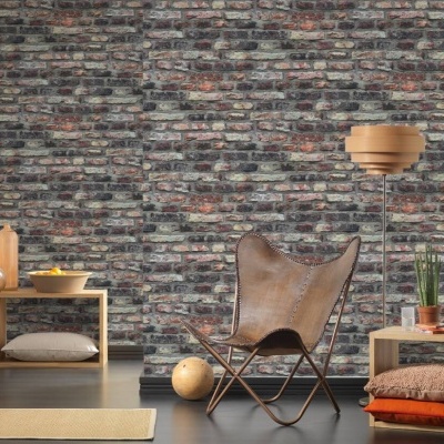 Sala com parede de tijolos, cadeira de couro castanho e candeeiro de pé em madeira clara