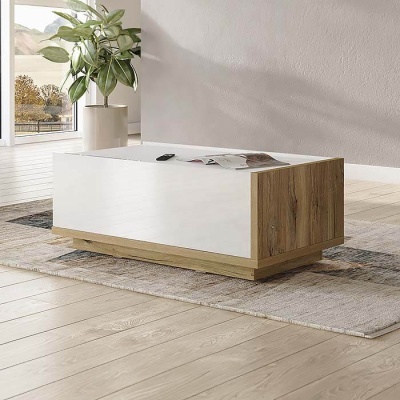 Mesa de centro retangular em madeira clara e branca sobre tapete cinza abstrato num interior com chão de madeira