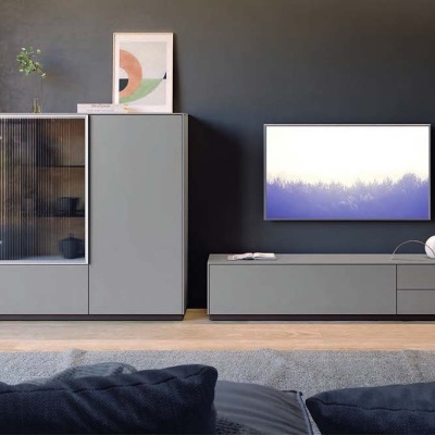 Conjunto de móveis cinza modernos contra parede preta em sala com chão de madeira clara