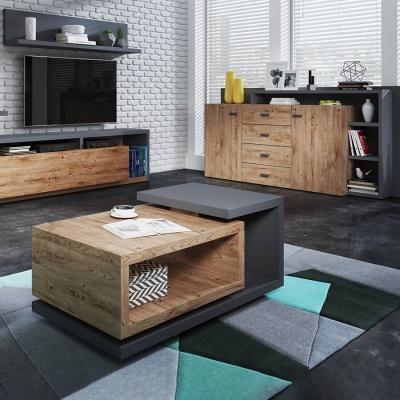 Sala de estar com móveis de madeira clara e cinza, parede de tijolo branco e tapete geométrico colorido