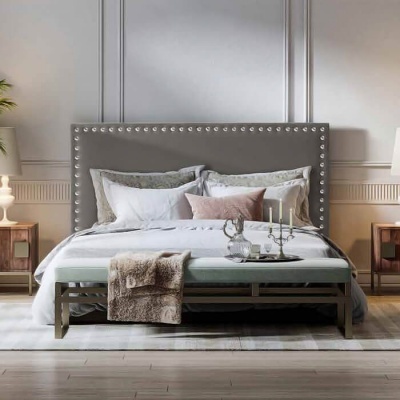 Quarto com cama de cabeceira cinza com tachas e decoração aconchegante