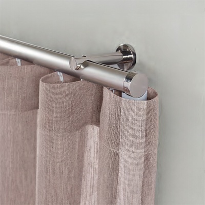 Varão de cortina metálico com cortinas bege penduradas