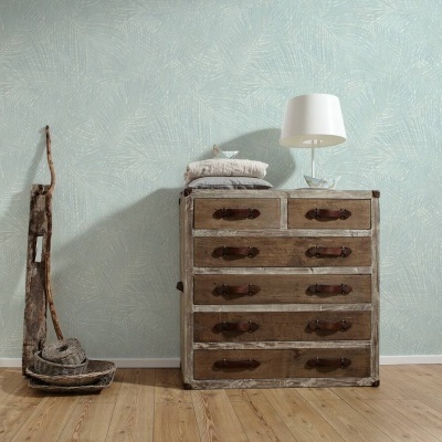Cómoda vintage em madeira com seis gavetas, almofadas, luminária branca e utensílios rústicos ao lado