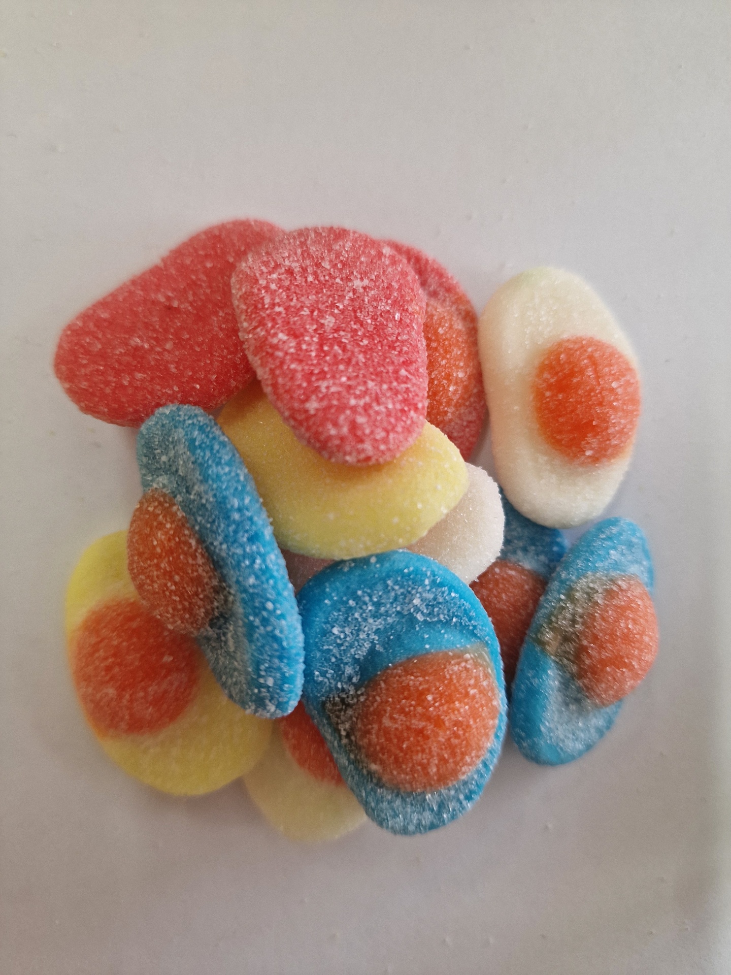 Gomas açucaradas coloridas em formas redondas com centro laranja em fundo branco