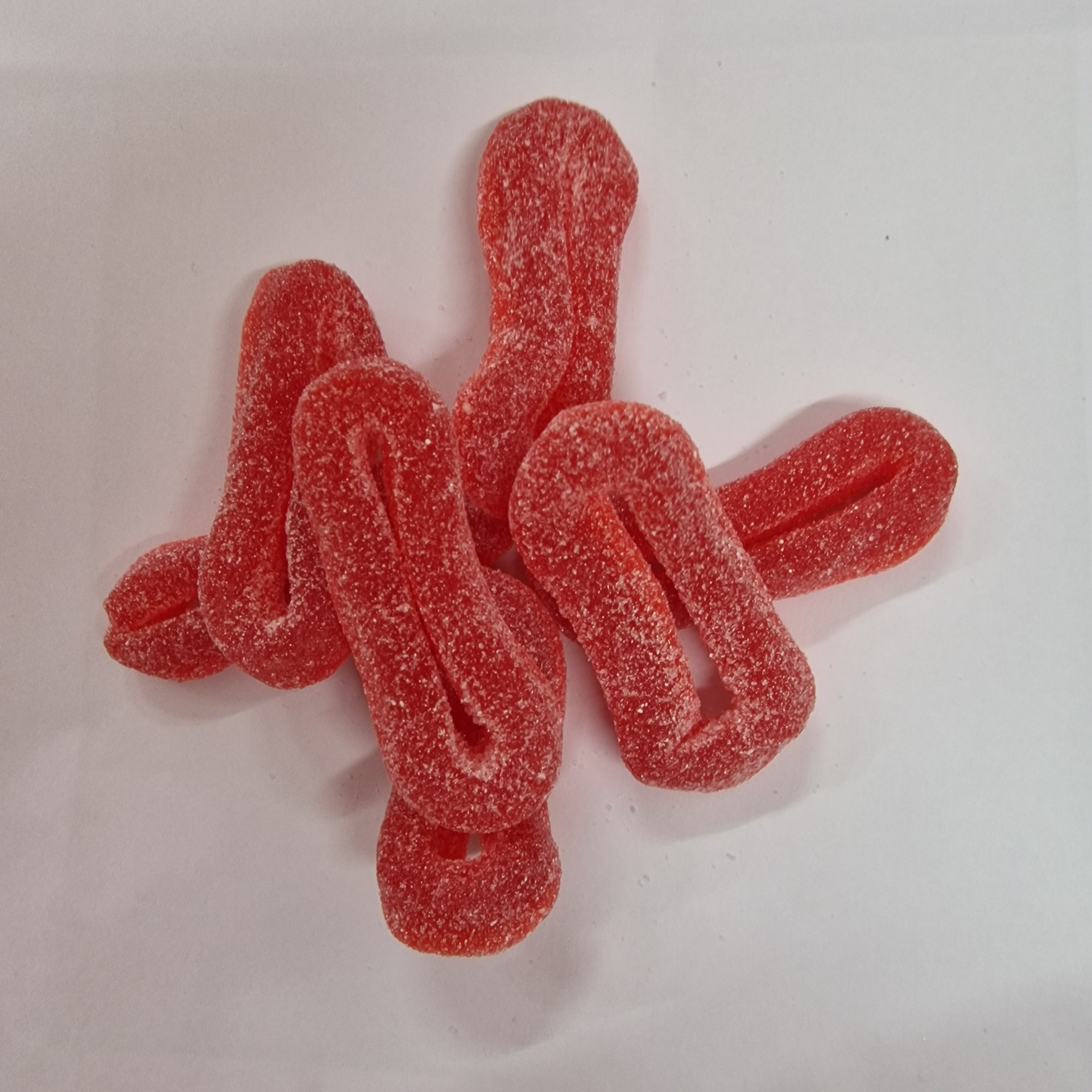 Gomas vermelhas açucaradas em forma de penico sobre fundo branco