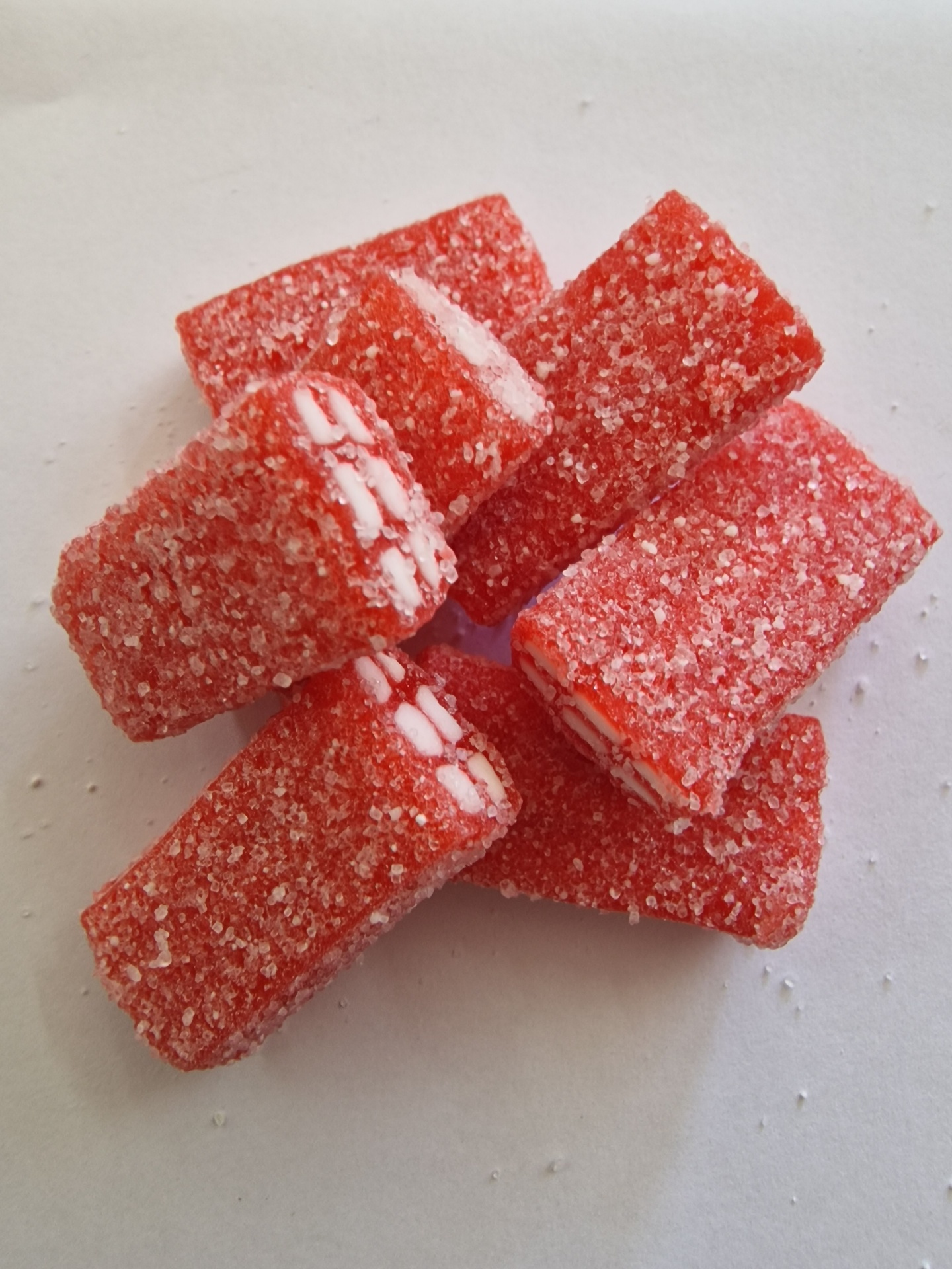 Gomas vermelhas retangulares cobertas com açúcar, interiores brancos visíveis