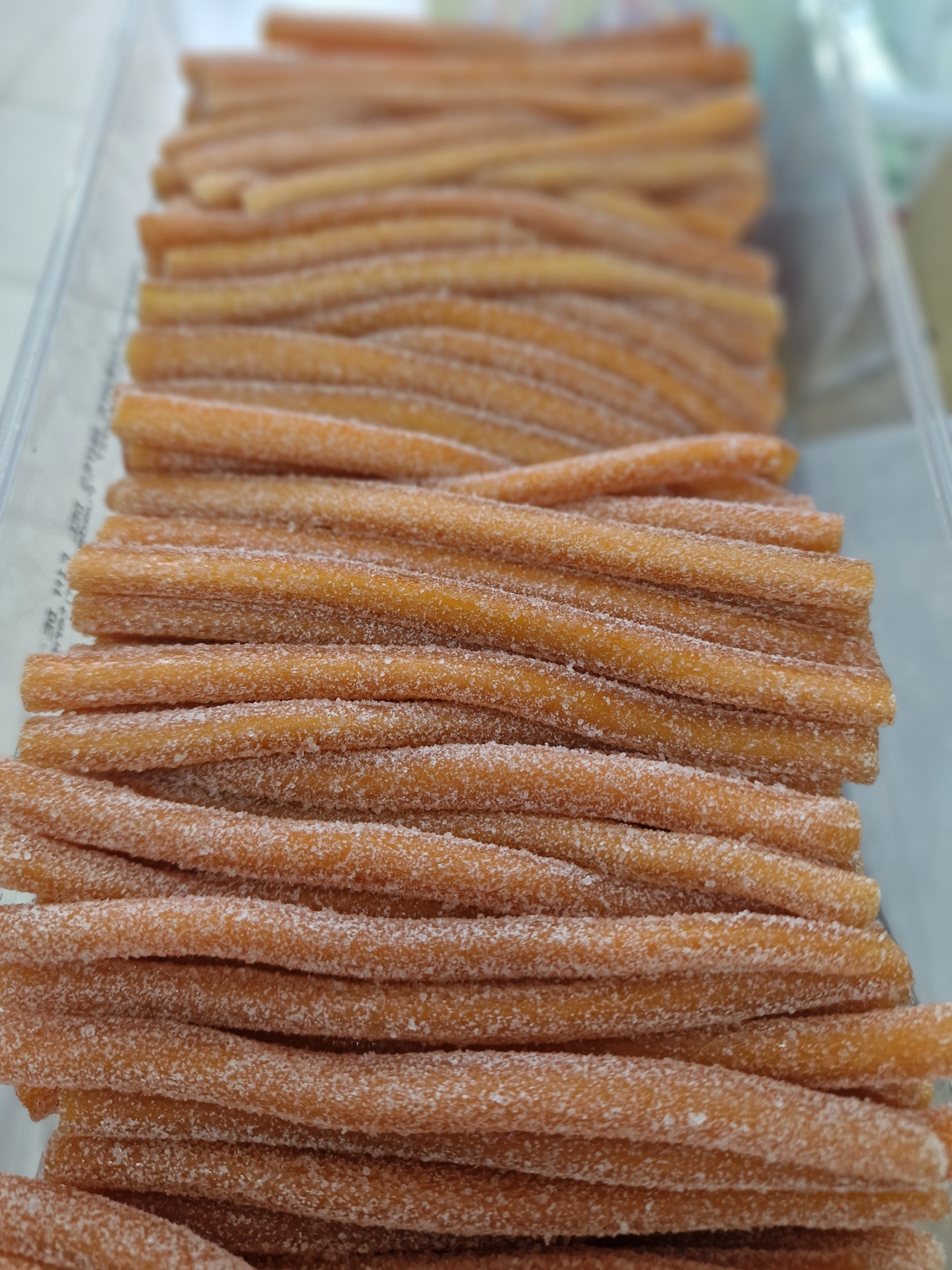 Doces compridos âmbar com cobertura cristalizada, alinhados em fileiras