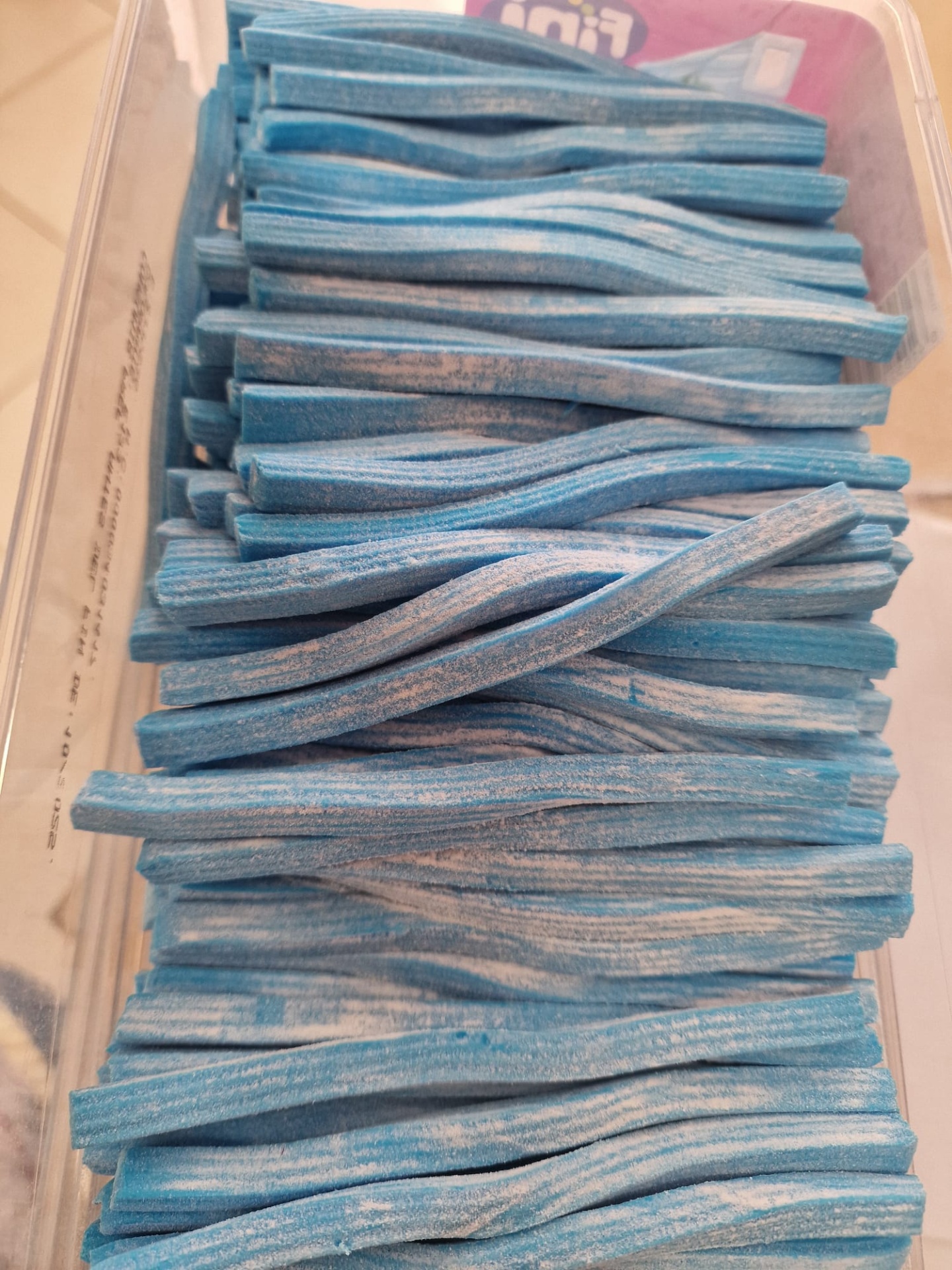 Tiras compridas azuis e brancas dentro de recipiente transparente