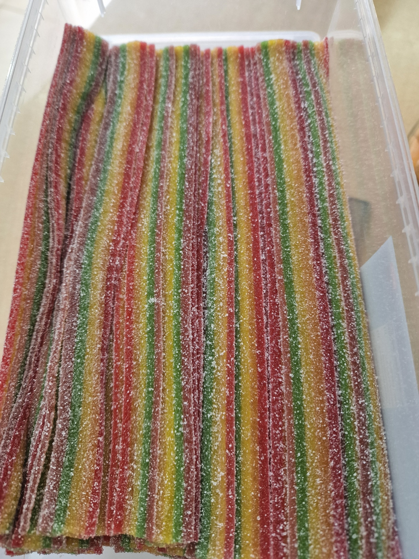 Tiras de gelatina coloridas cobertas de açúcar em embalagem transparente