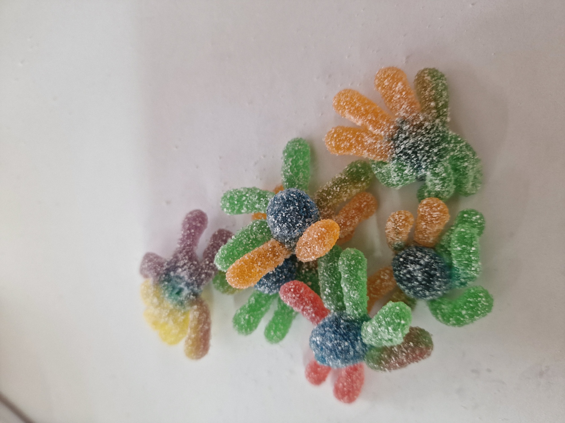 Guloseimas de goma em forma de aranha coloridas sobre superfície branca