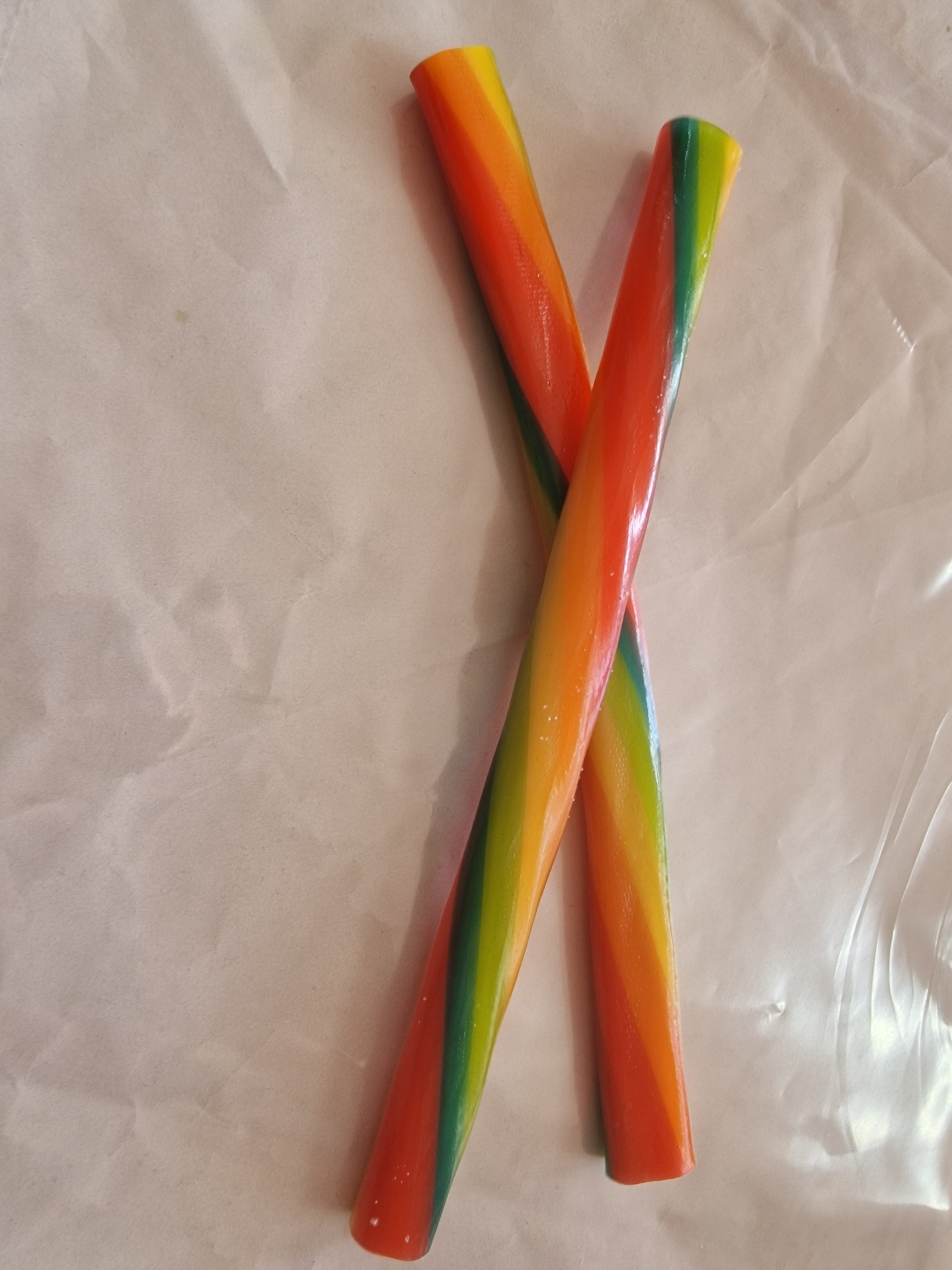 Dois tubos rígidos coloridos em espiral sobre superfície branca