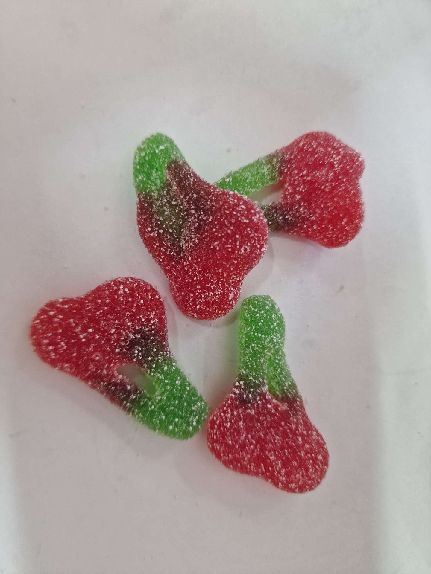 Gomas em forma de cereja com açúcar em superfície branca