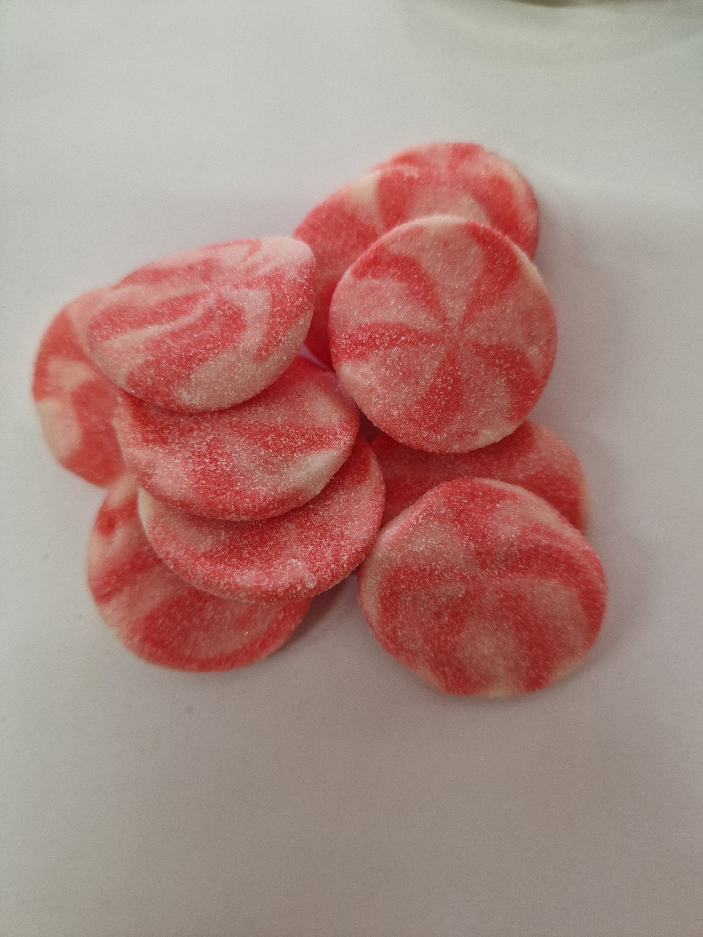 Doces redondos vermelho e branco com textura açucarada