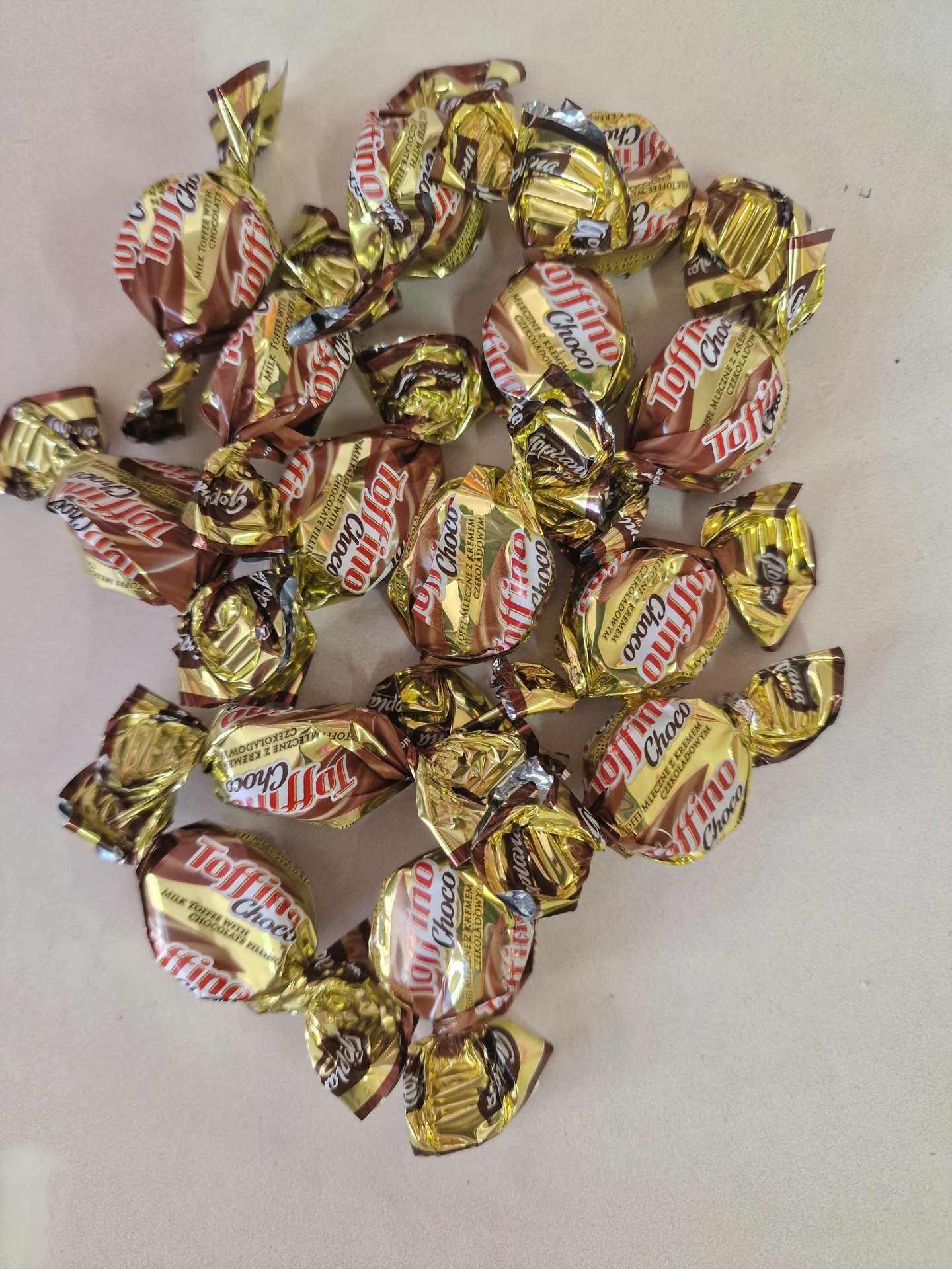 Vários bombons Toffino Choco embalados individualmente sobre superfície clara