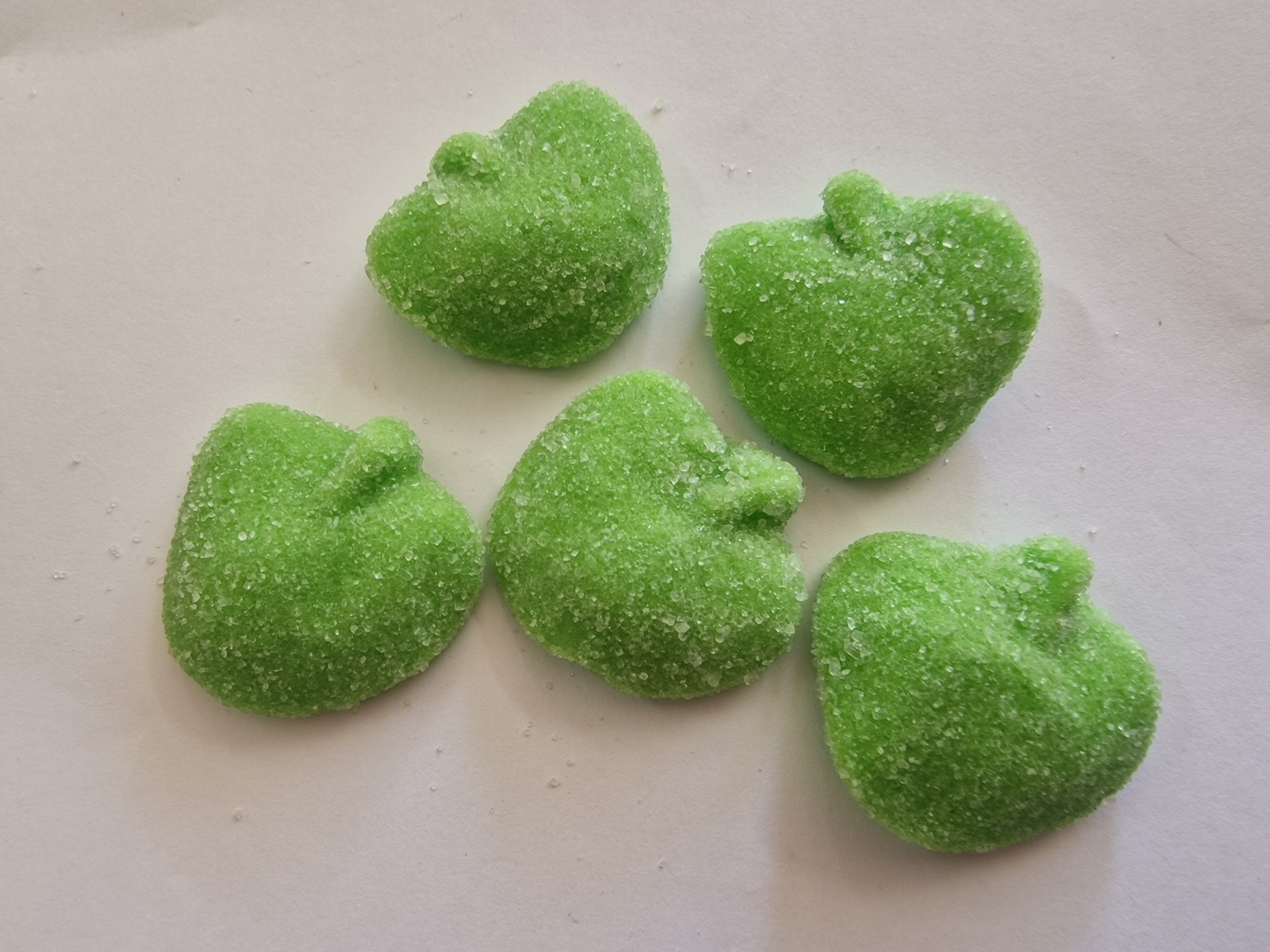 Doces verdes em forma de maçã cobertos de açúcar