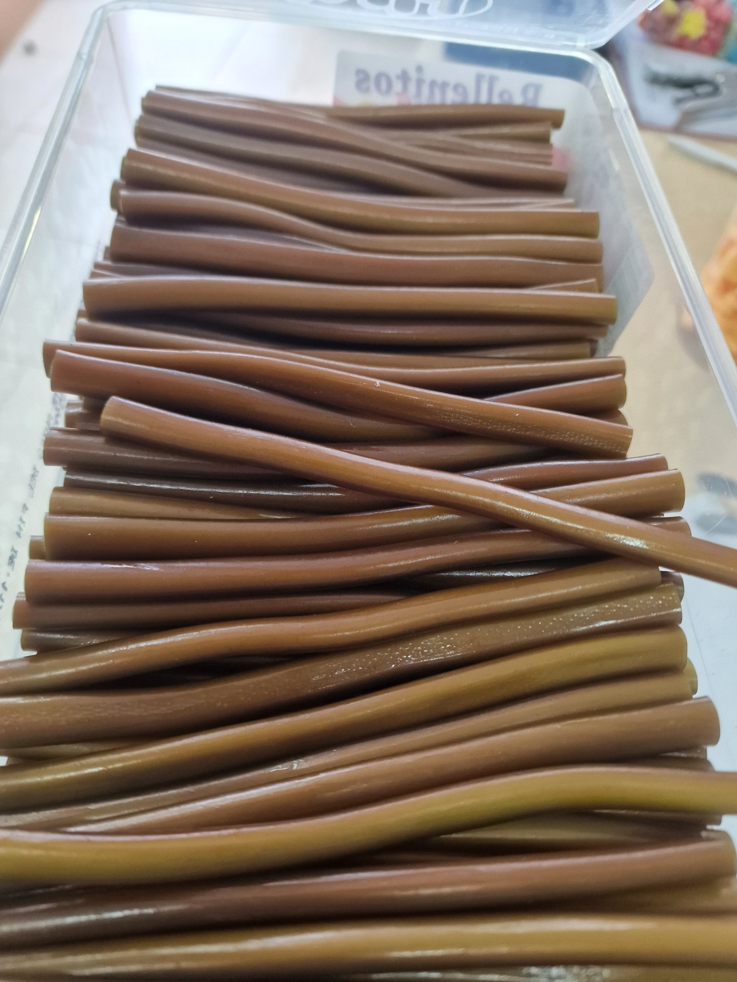 Varetas castanhas dentro de caixa de plástico com etiqueta 'Palmitos'