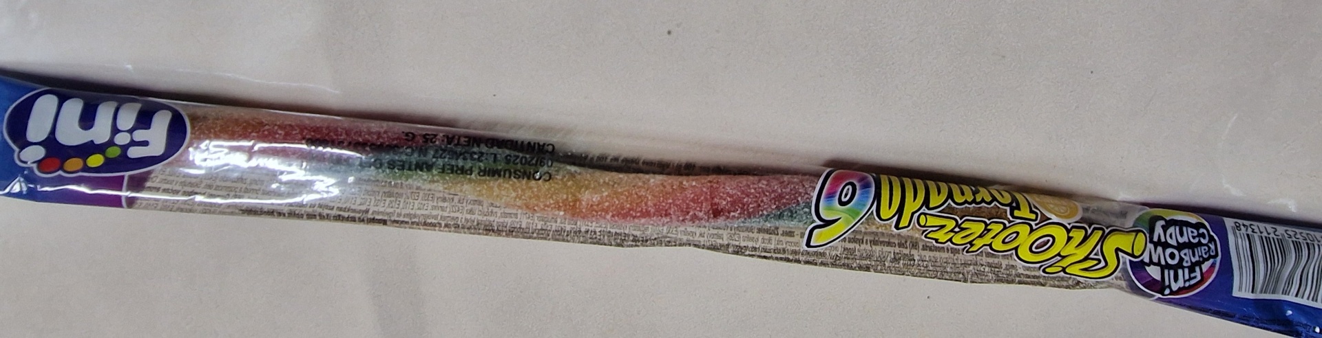 Pacote plástico transparente com doce granulado colorido e rótulo com texto 'Smoke mill' e 'Fini'