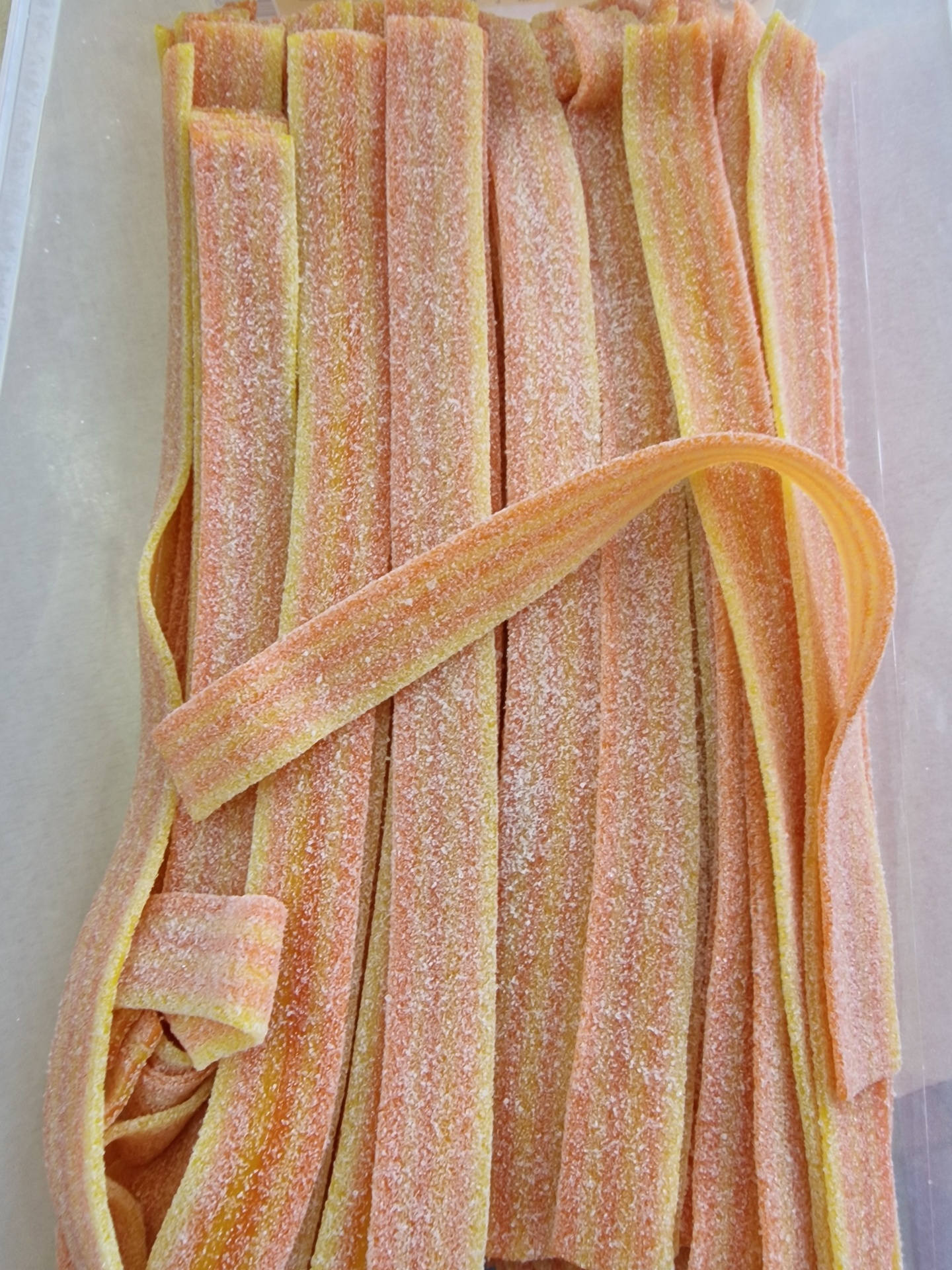 Fitas de goma açucaradas rosa e amarelas com açúcar