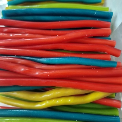 Cordões de goma coloridos em amarelo, azul, vermelho e verde sobre fundo branco