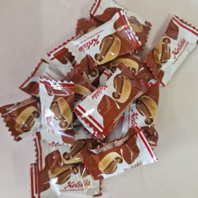 Pacotes de pastilha elástica Kellolia em embalagem branca e castanha