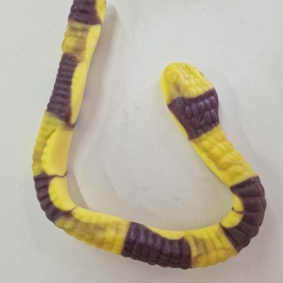 Brinquedo em forma de cobra amarelo e roxo sobre fundo branco