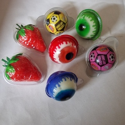 Brinquedos pequenos com formatos de morango, bolas de futebol e olhos coloridos