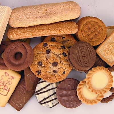 Diversos tipos de bolachas e biscoitos variados coloridos e texturizados sobre uma superfície branca.