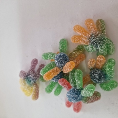 Guloseimas de goma em forma de aranha coloridas sobre superfície branca