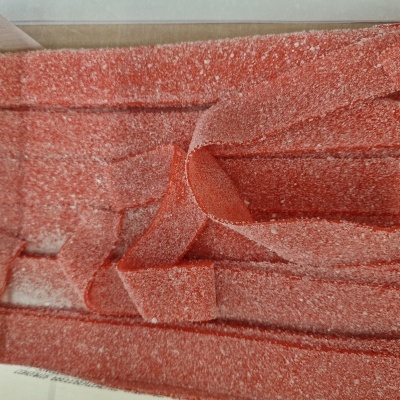 Tiras de doce vermelhas cobertas de açúcar em caixa transparente