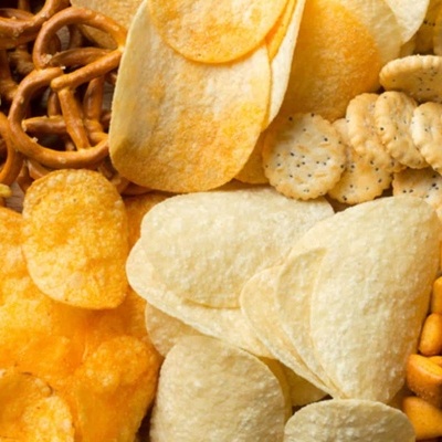 variedade de snacks salgados como batatas fritas, pretzels, nachos, bolachas e cubos de queijo