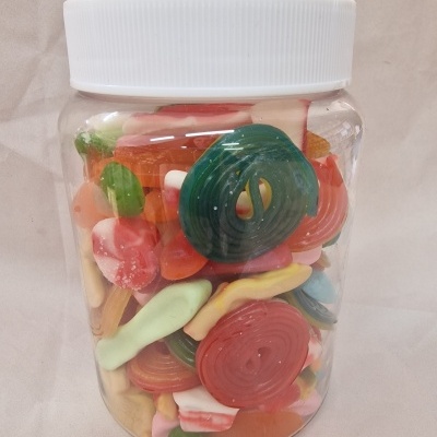 Frasco plástico transparente com tampa branca cheio de rebuçados coloridos variados